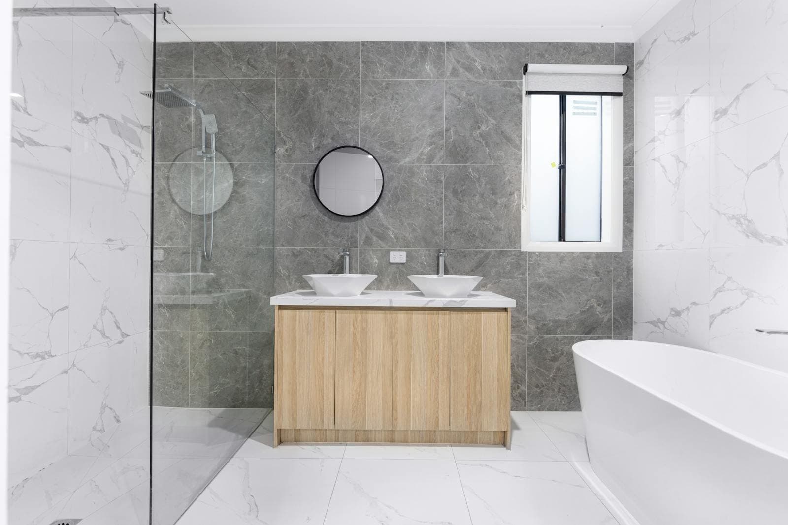 Modern bathroom remodel with walk-in shower, tile surround, and natural light